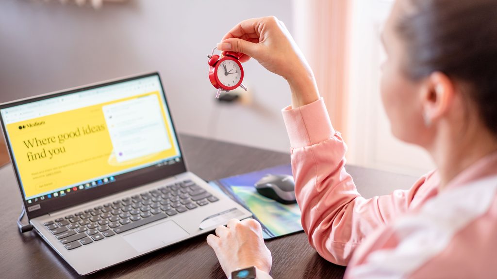 Woman with laptop and clock