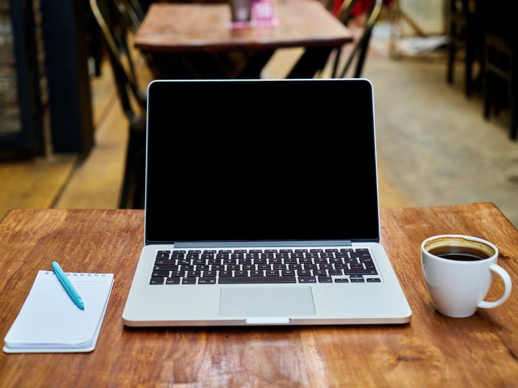 Laptop on the table, coffee and notebook