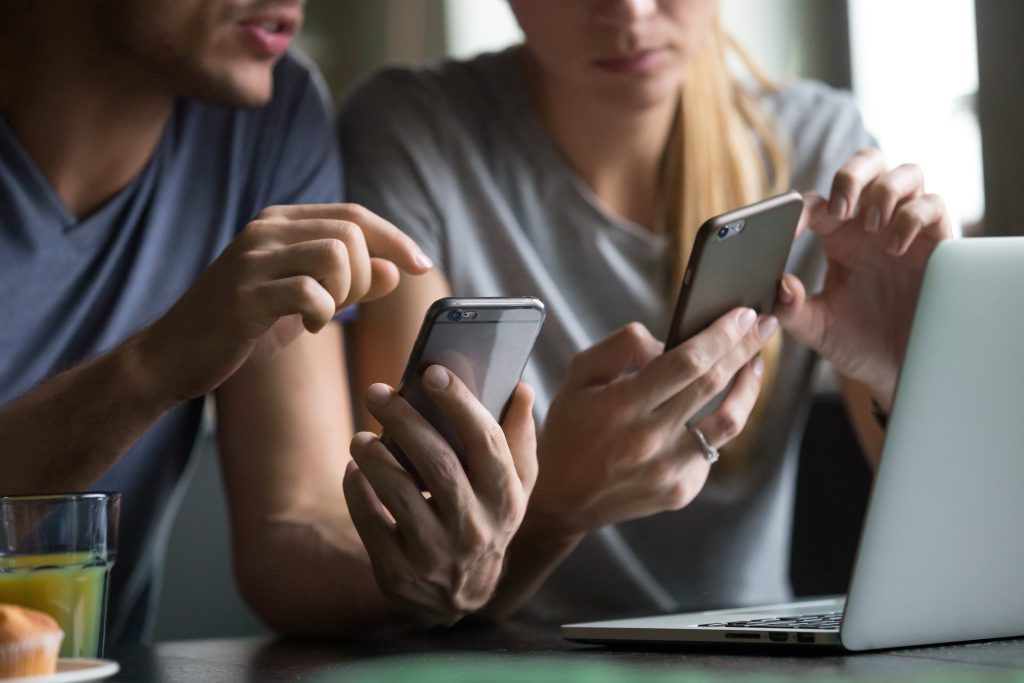 Man and woman using smartphones discussing mobile apps